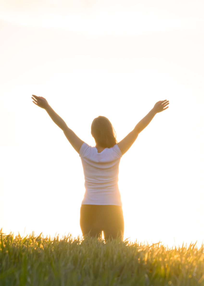 Woman standing in an open space enjoying the sun.